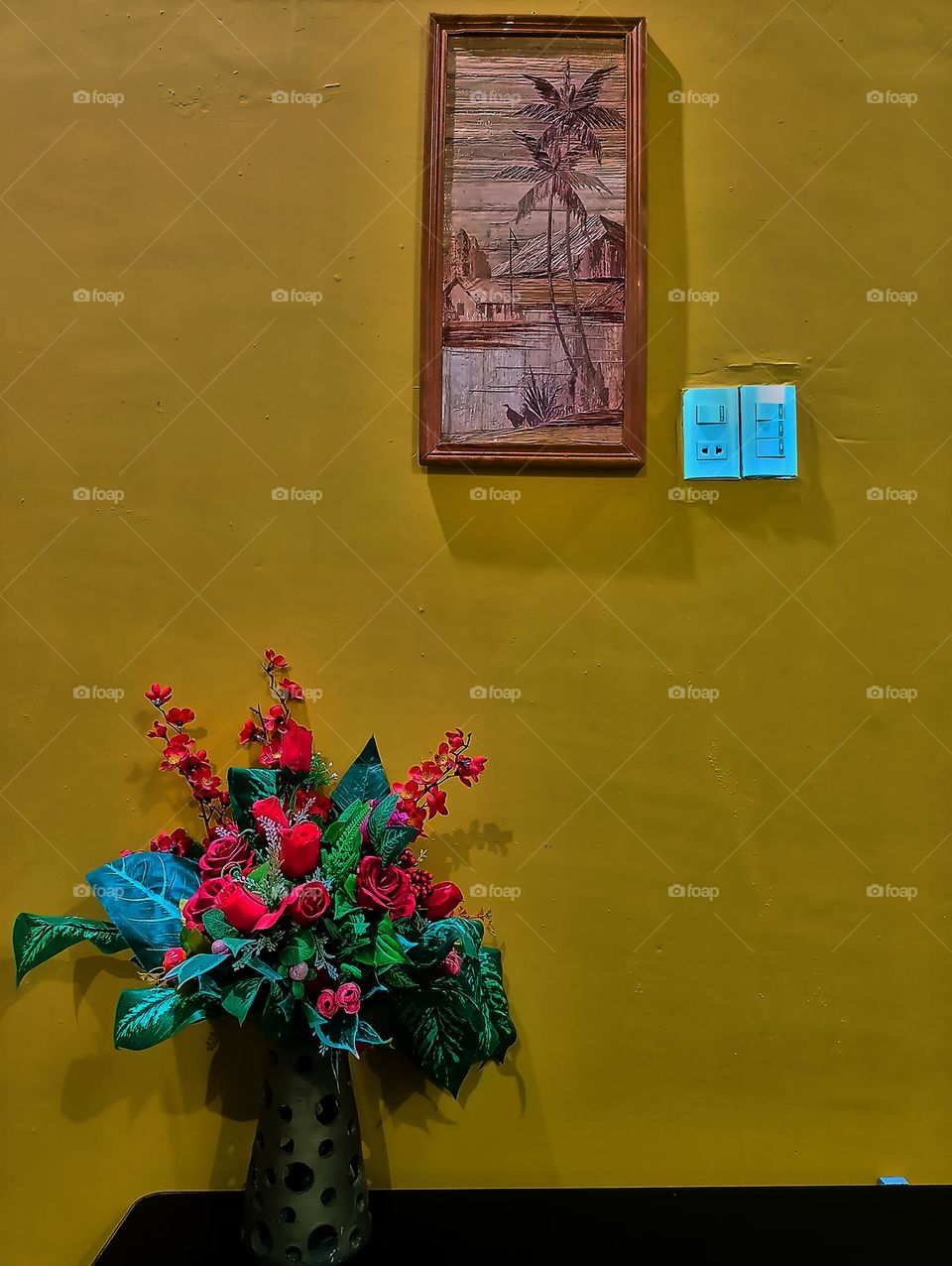 Interior room in yellow wall with single plant and single picture frame. Light background with copy space.