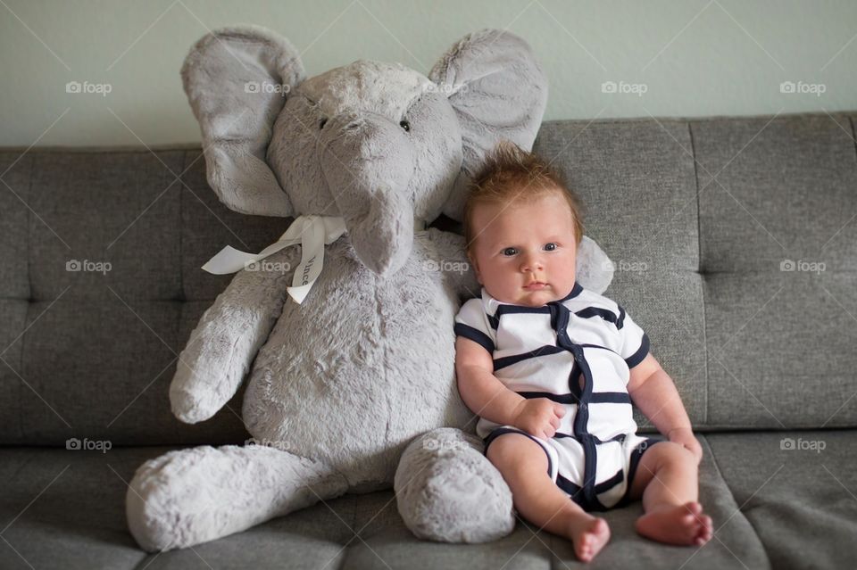 Cute baby sitting with he's elephant 
