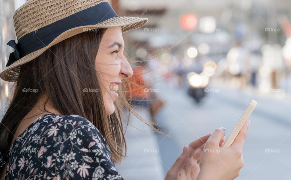 Laughing girl with smartphone, street photography 
