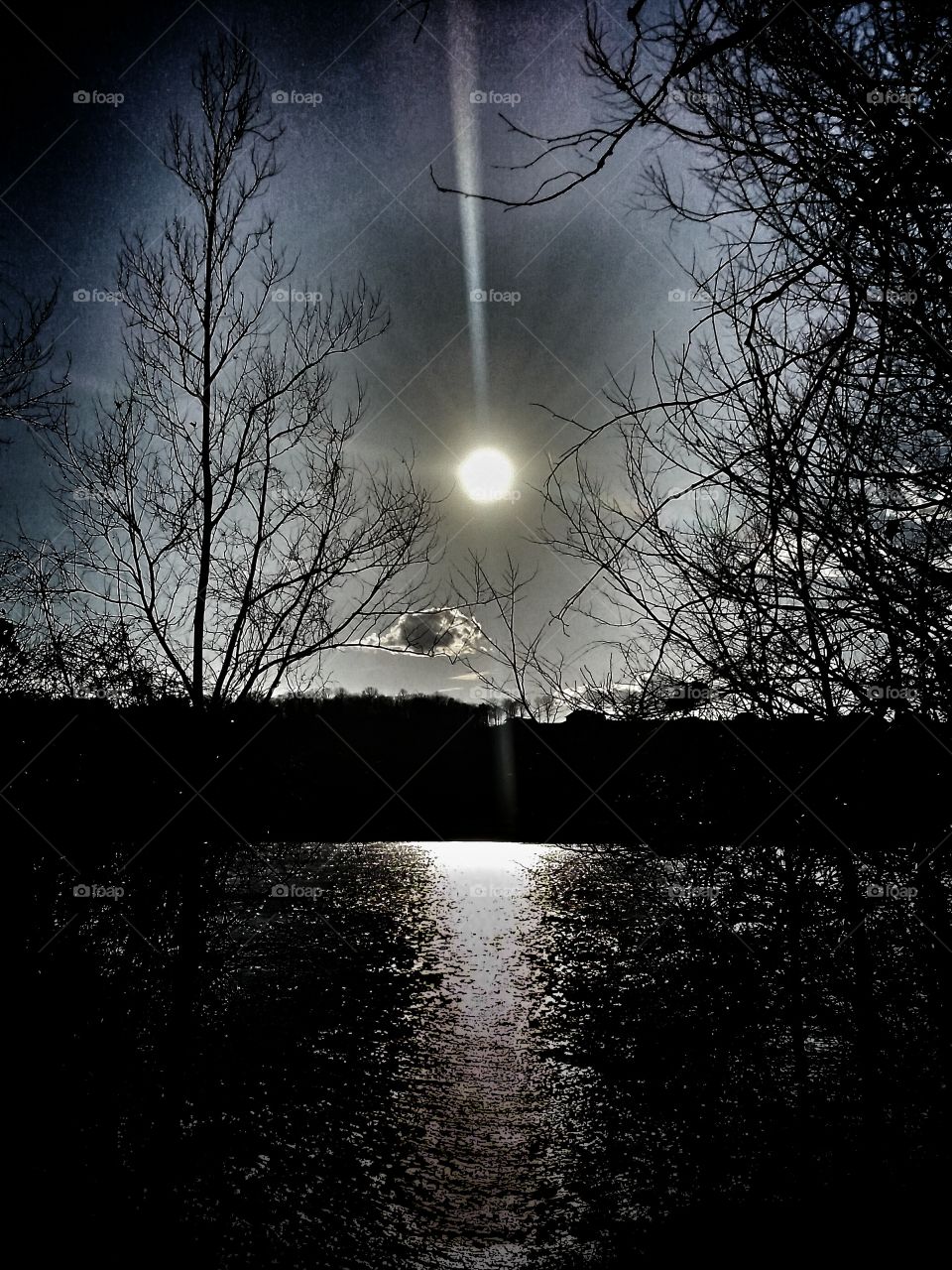 Sunburst. Reflective Sunset along river path.