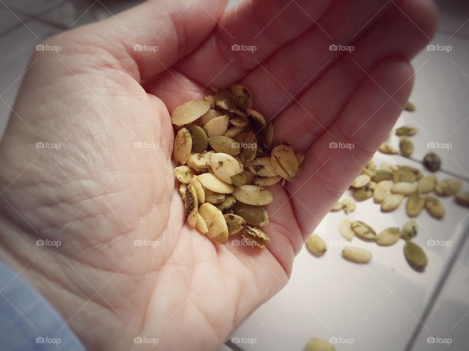 Person showing pumpkin seeds on palm