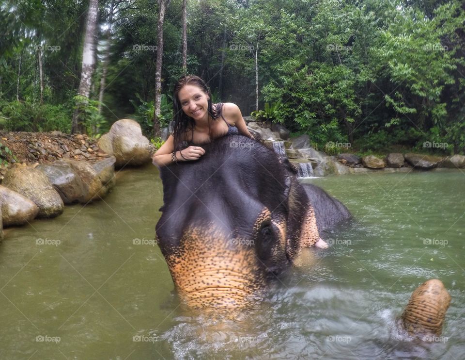 Woman play with elephant in river