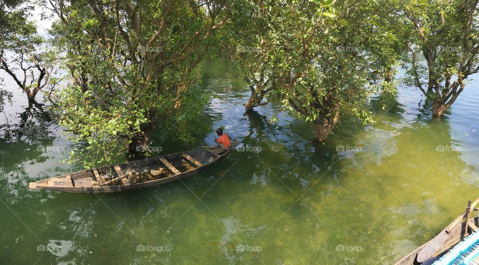 A boy in a boat in a jungle 