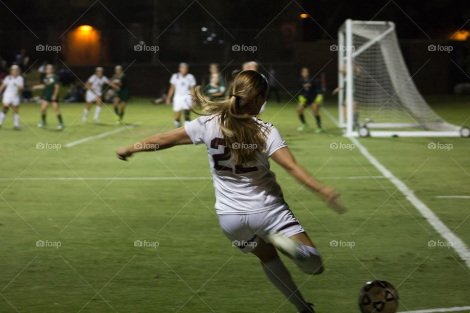 A college athlete making a kick that helped to win the game 