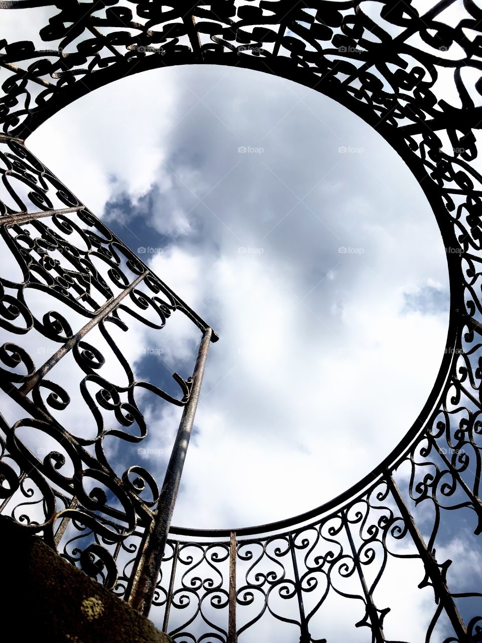 wicker metal romantic fence, bottom view to the top to the sky in a round hole