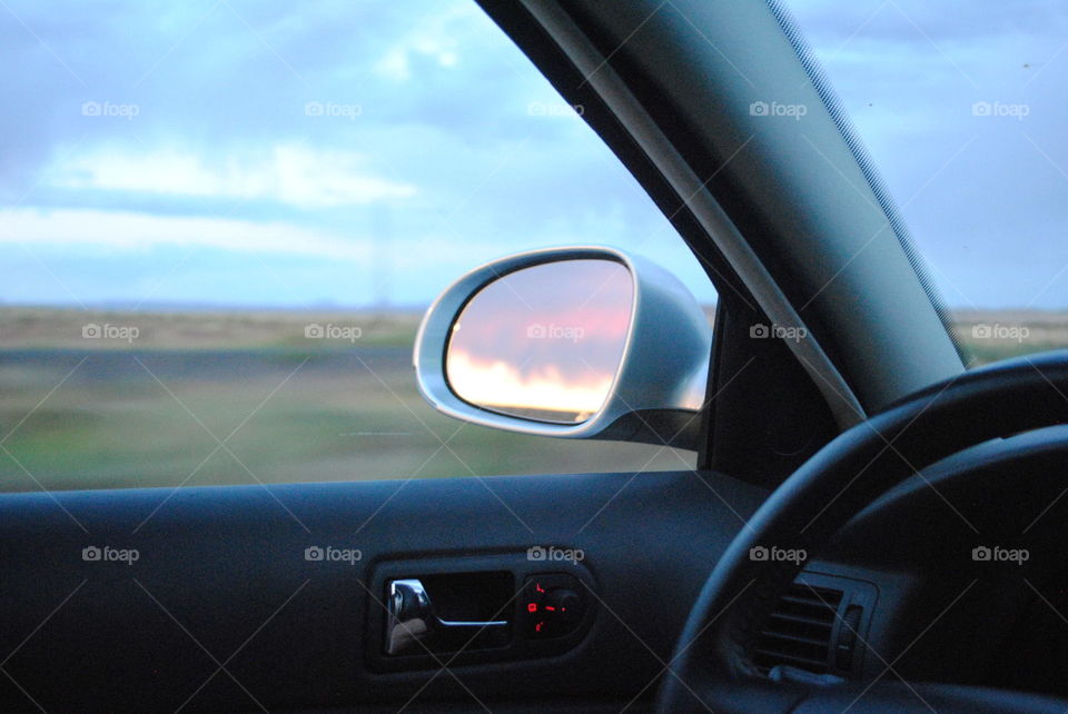 Sunset in the mirror of a car