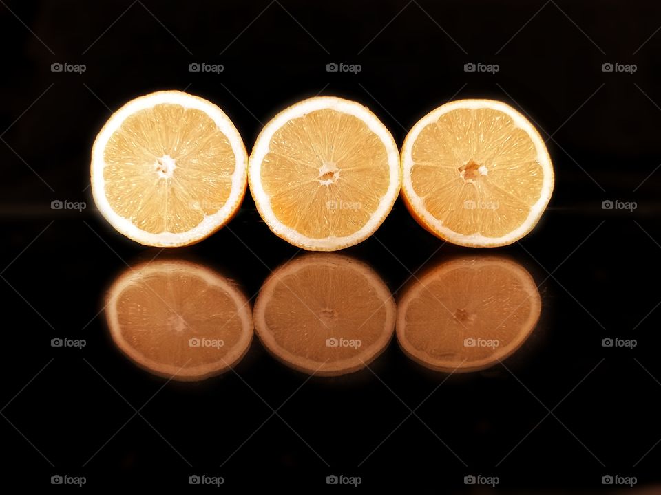 reflection on black glass of lemon slices