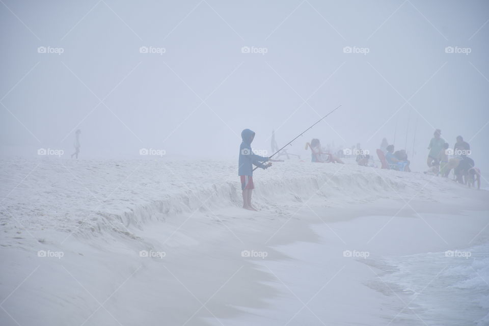 Fishing on the beach in fog