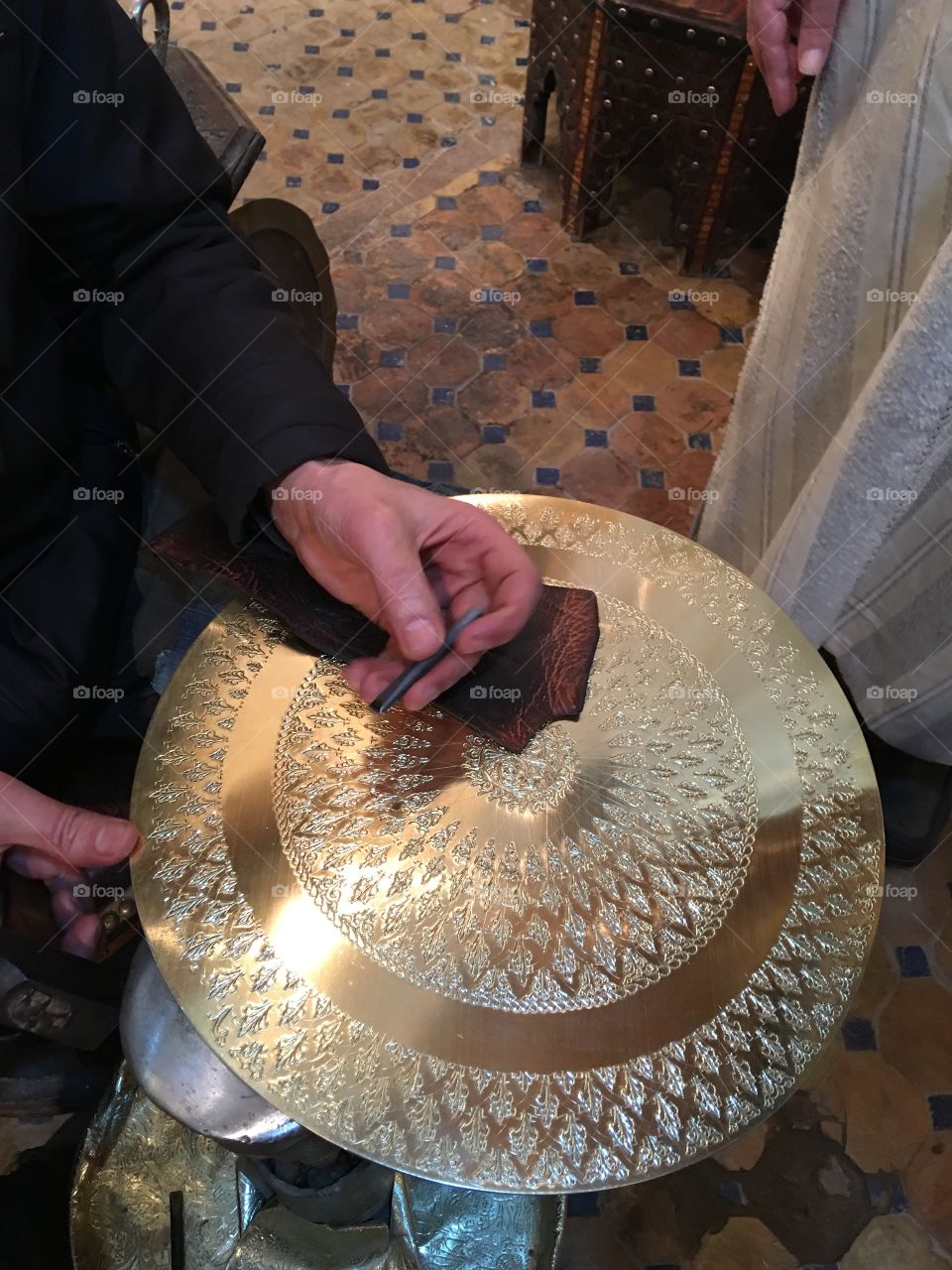 Craftsman creating art while making a plate out of metal 