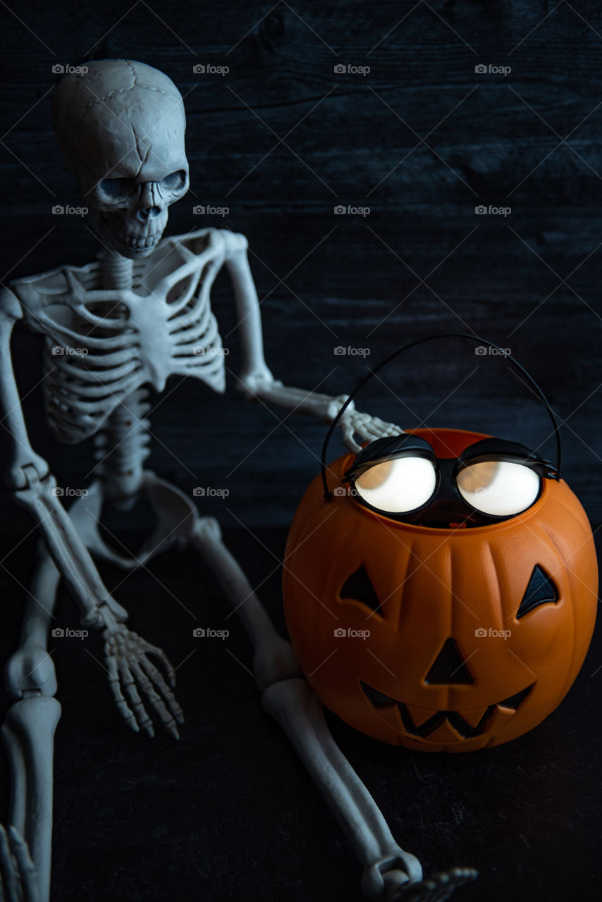Glowing eyes Halloween decoration next to a skeleton 