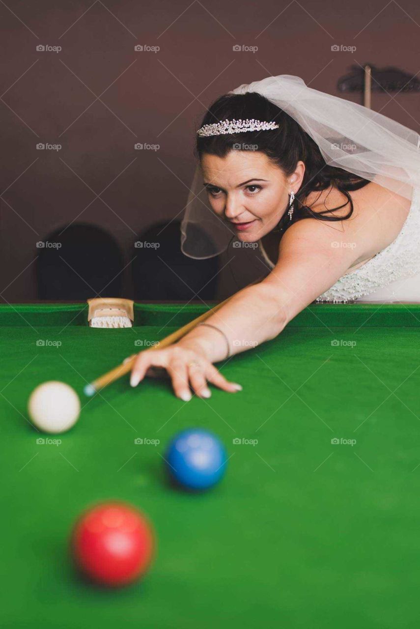 blushing bride trying her luck at snooker.