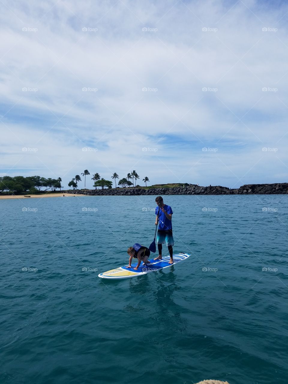Boy gets a lesson on paddleboarding at Pokai Bay