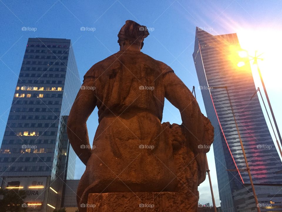 Behind a statue's back in a Business Center of Warsaw City