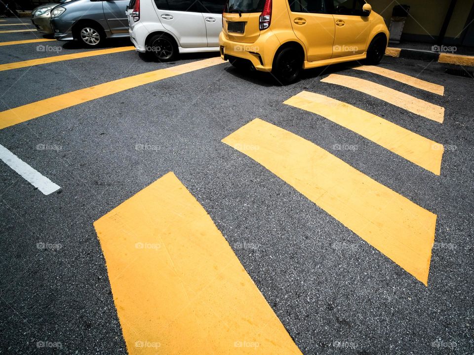 Yellow crossings and yellow car parked on the street