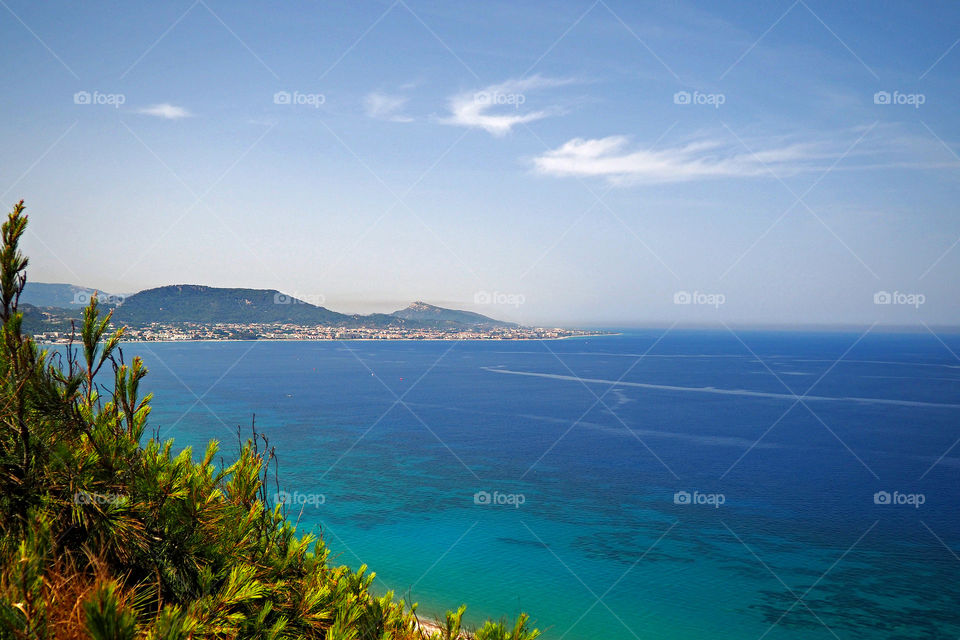 Sea in front of mountains against sky