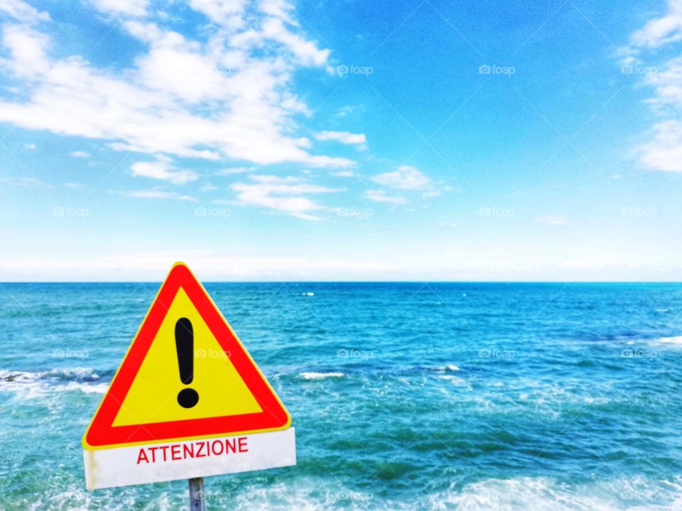 danger sign in the foreground and the sea in the background
