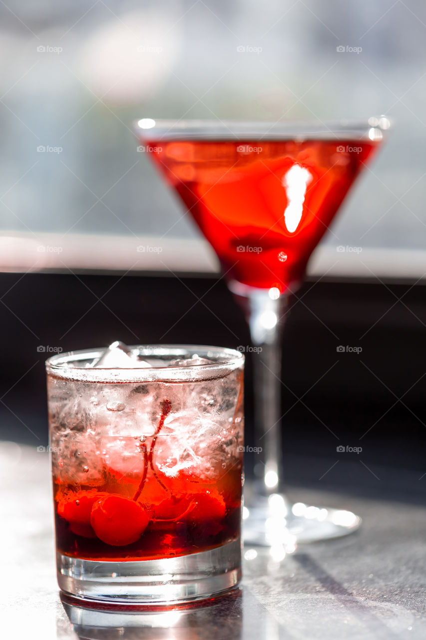 Two red colored cocktails at the bar. Happy hour drinks.