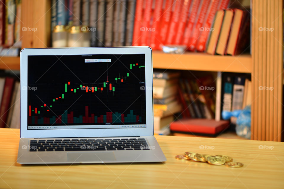 on the table golden cryptocurrency coins and laptop