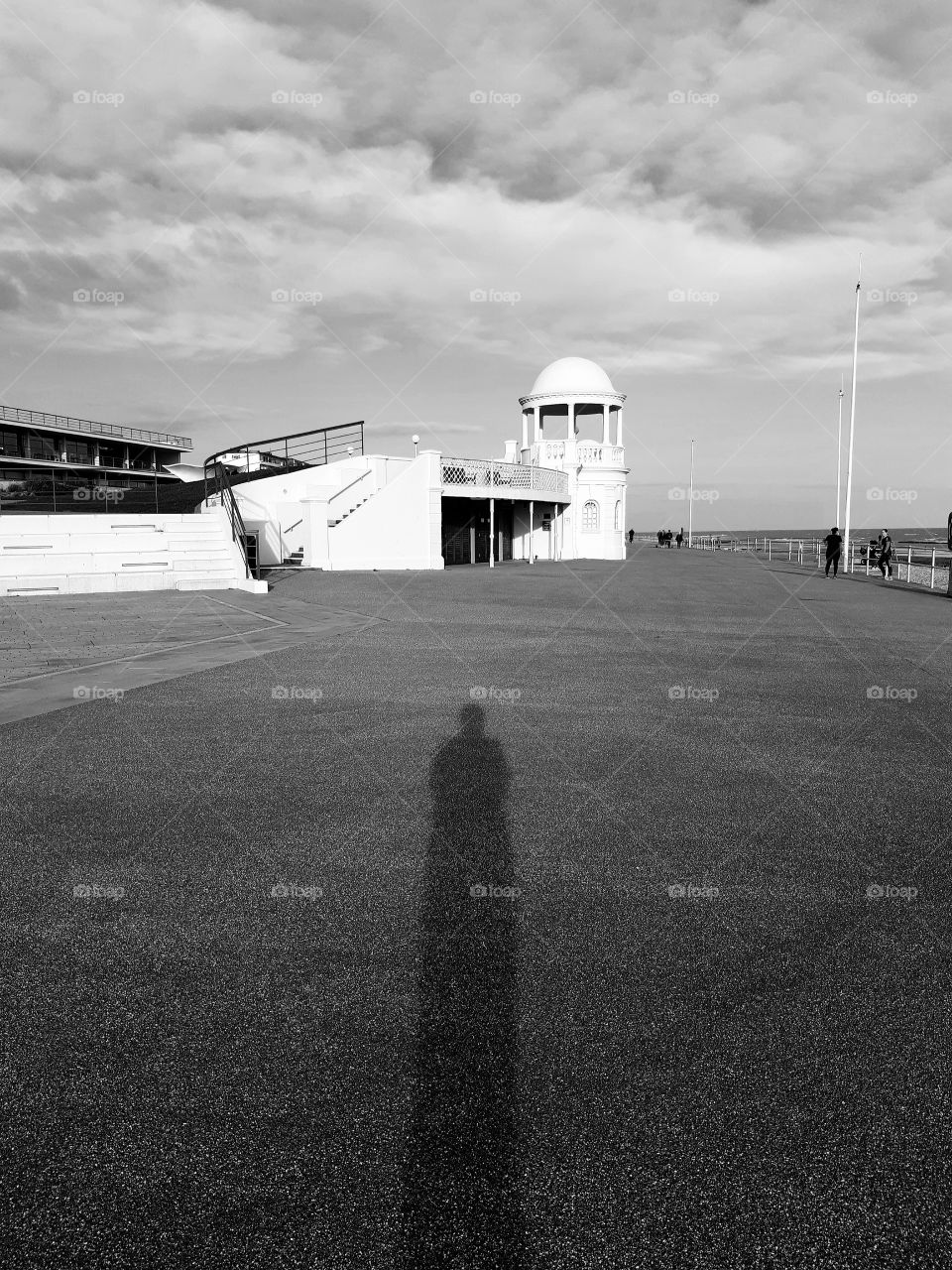 It's called 'social distancing' as my shadow and I take a quiet stroll along the promenade and towards Bexhill's Pavilion by the calm water's edge. March 2020.