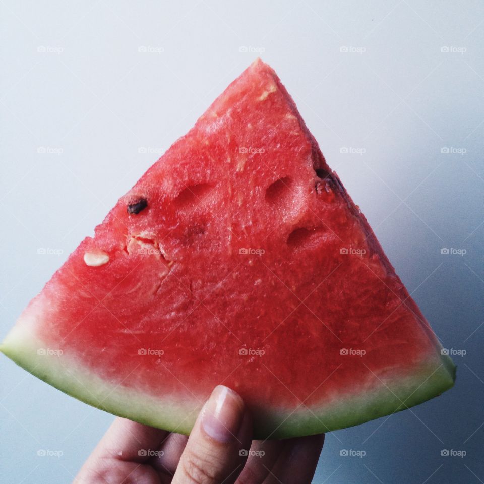 A person holding watermelon slice