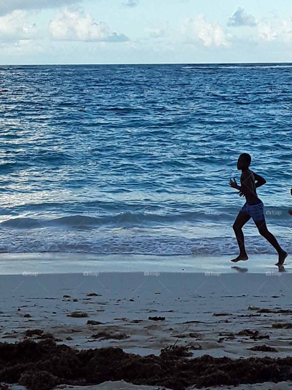 ocean and boy running on the beach