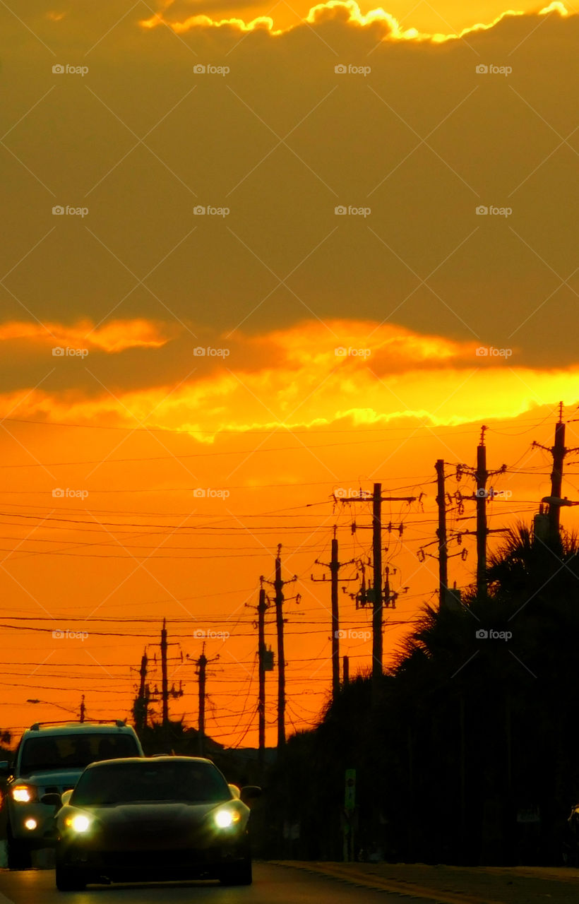 Illuminated car on road at sunset