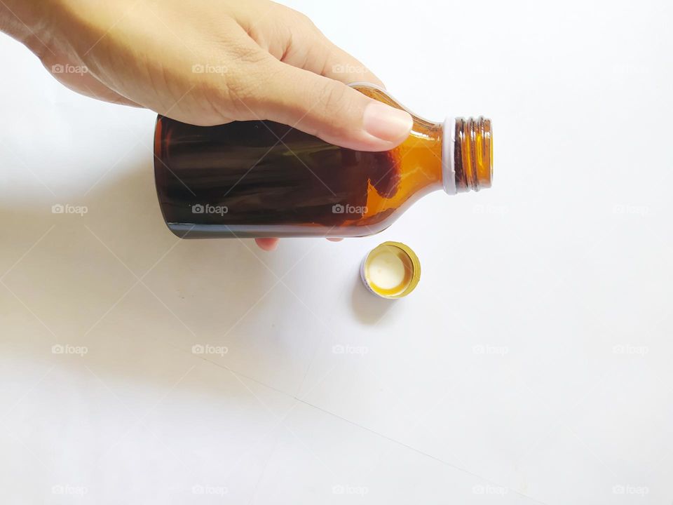 Finished pouring liquid cough medicine into the bottle cap
