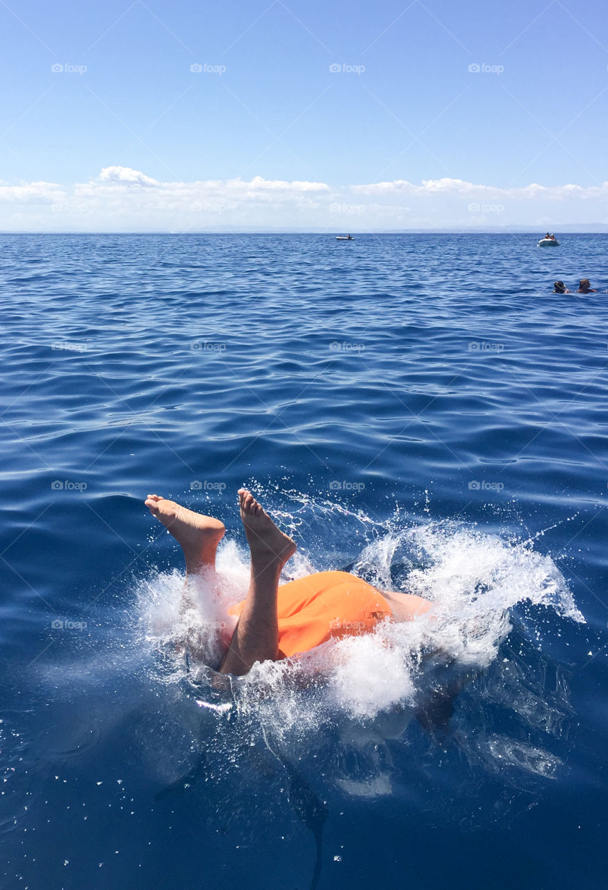 Young man jumping into water