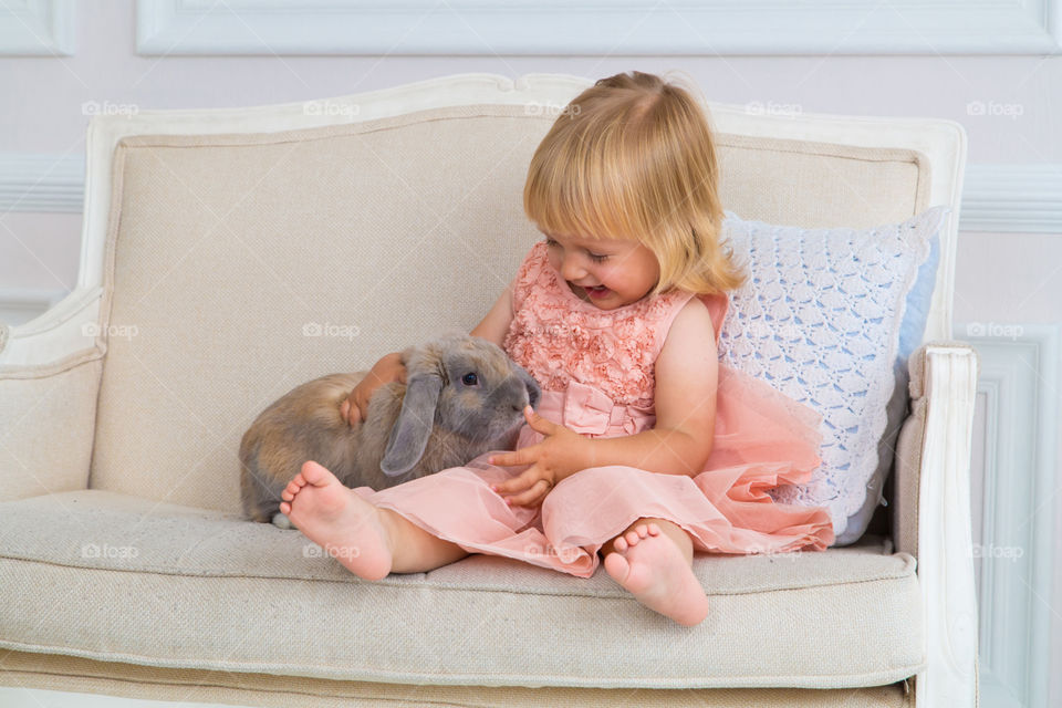 Little girl with blonde hair and rabbit 