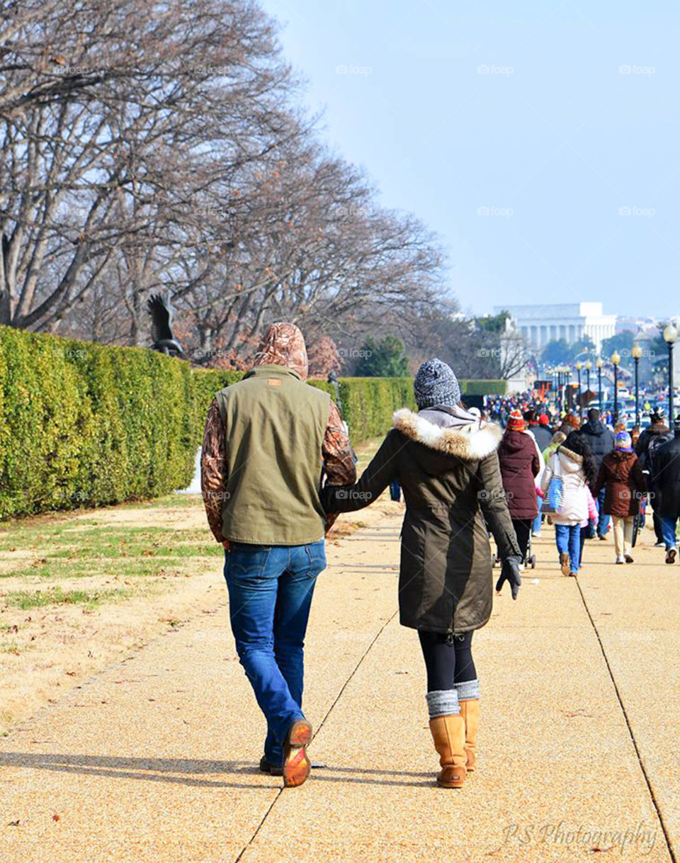 warmly dressed couple. cute couple walking hand in hand at Arlington National Cemetery ring the Wreaths Across America ceremonies
