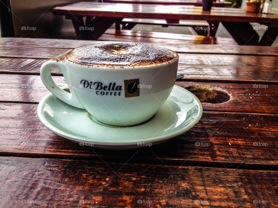 Cup of cappuccino coffee on wooden table