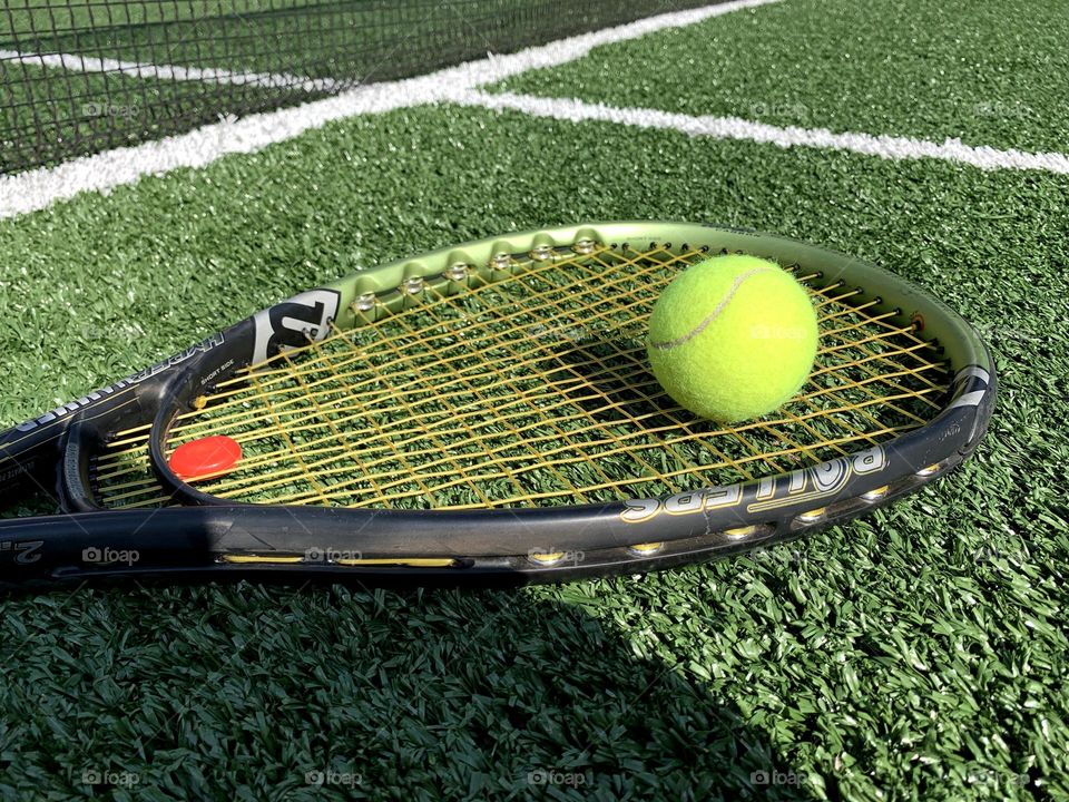 Tennis racket and ball on grass court