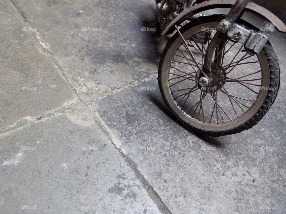 Old, rusty and broken toy bicycle