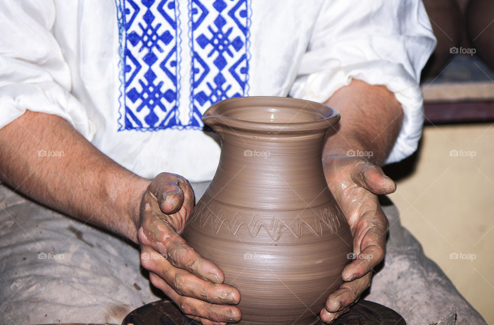 Close-up of male potters hands making vase