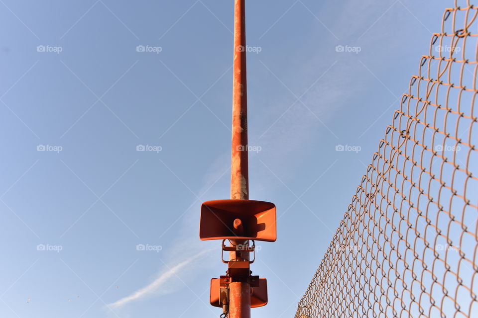 Orange colored loudspeaker belonging to a public announcement system.