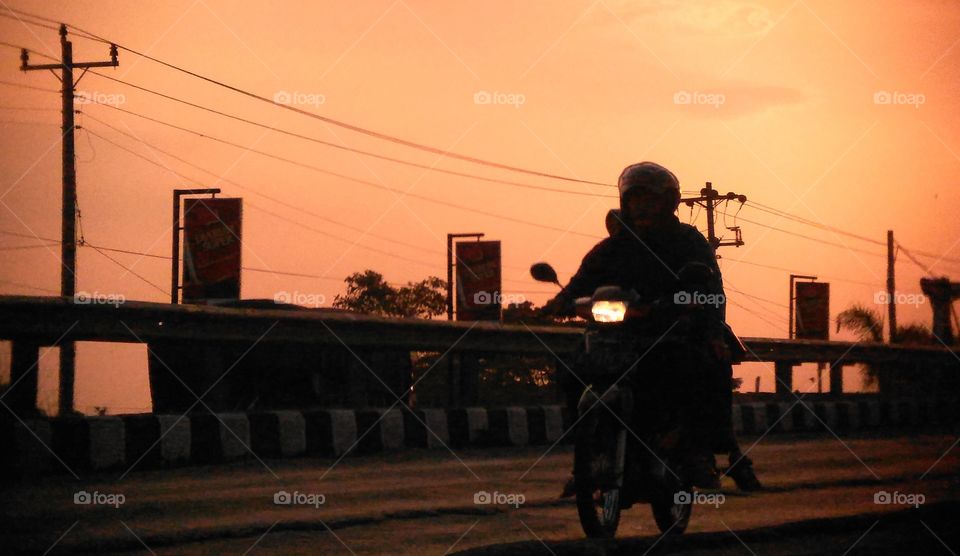 Motorcycle silhouette on the road in the evening