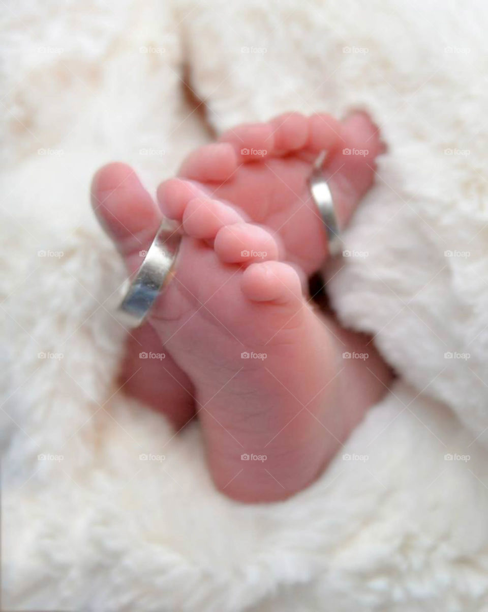 tiny baby toes & wedding rings. cute baby feet and tiny toes wearing parent's wedding bands