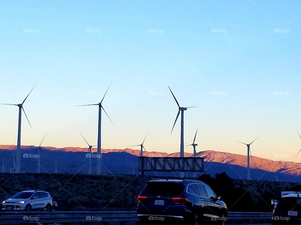 Life in Motion: cars commute home from work as the sun sets behind the desert hills.