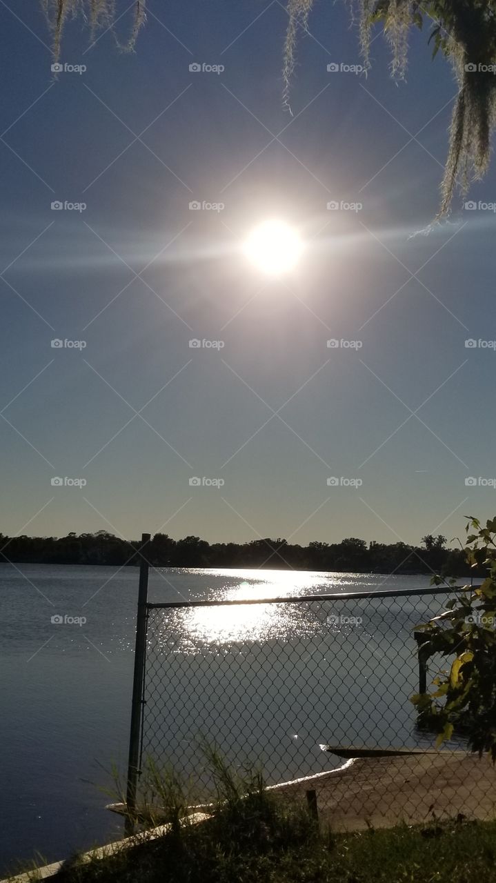 Reflection of the Sun over a beautiful lake in the Backyard of a Lake House. Bright and Simple.