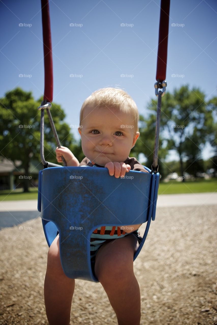 Baby boy in baby swing