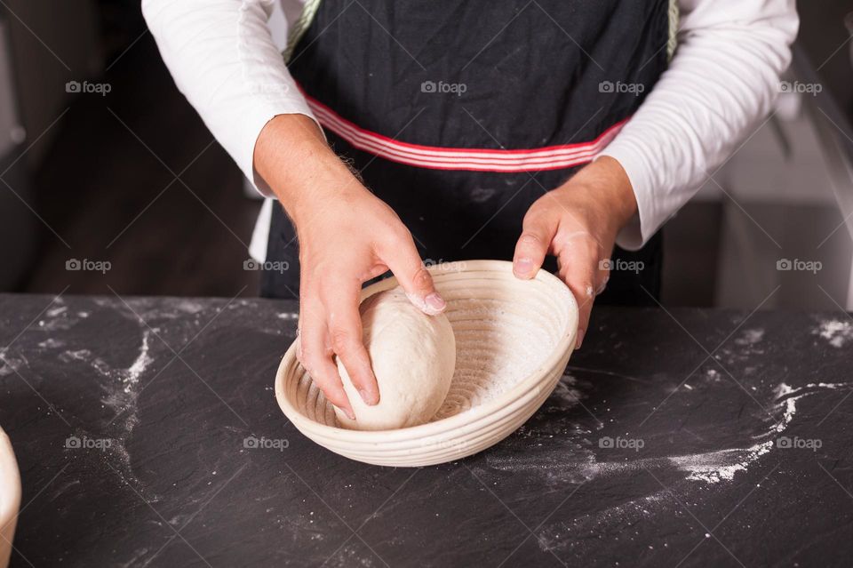 Placing round boule of dough in baking tray. Baking bread at home.