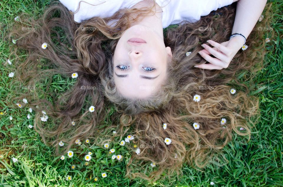 Woman with beautiful natural hair on background of daisies