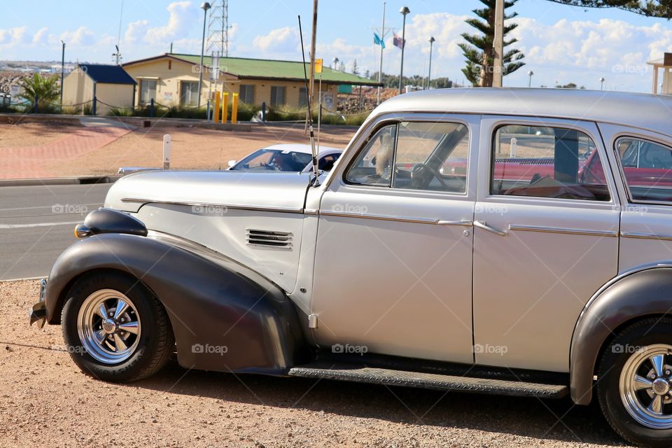 Classic collector car silver sedan parked outdoors 