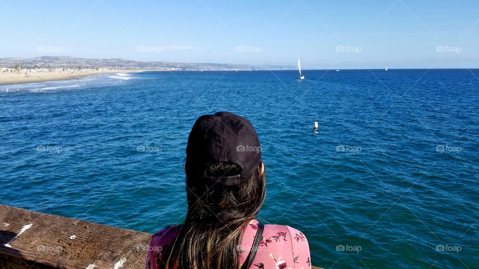 woman looking out the sea wearinga cap