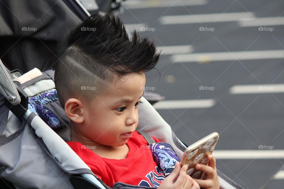 A little kid using his mobile phone