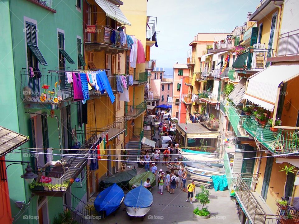 Laundry, winding streets, boats, and colorful houses in the village of vernazza in Cinque Terre, Italy