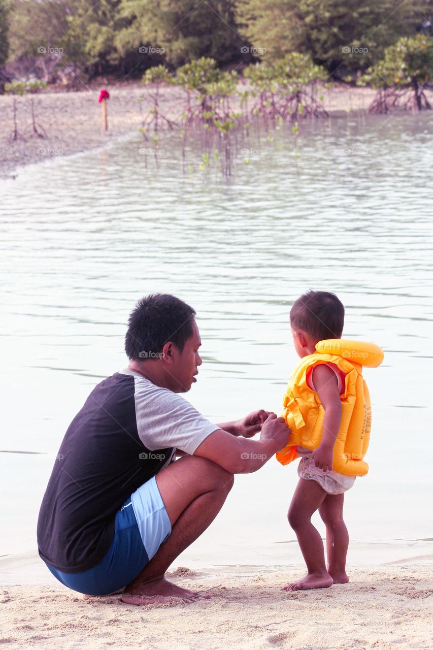 View of a man and a little boy at the beach