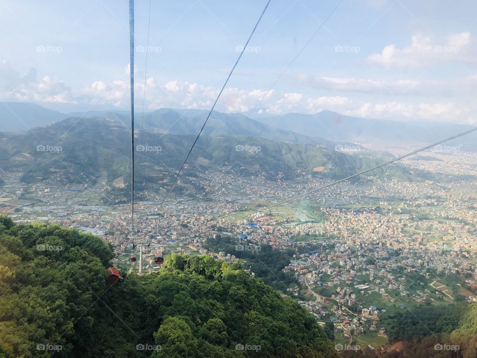 Ropeway with view of city and greenery.