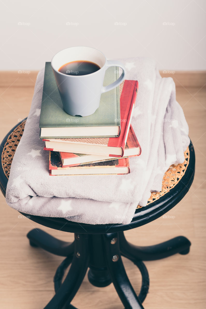 A few books with cup of coffee and blanket. Cozy and comfortable. Time for relax. Spending leisure time on reading. Learning from books. Studying for the next exams