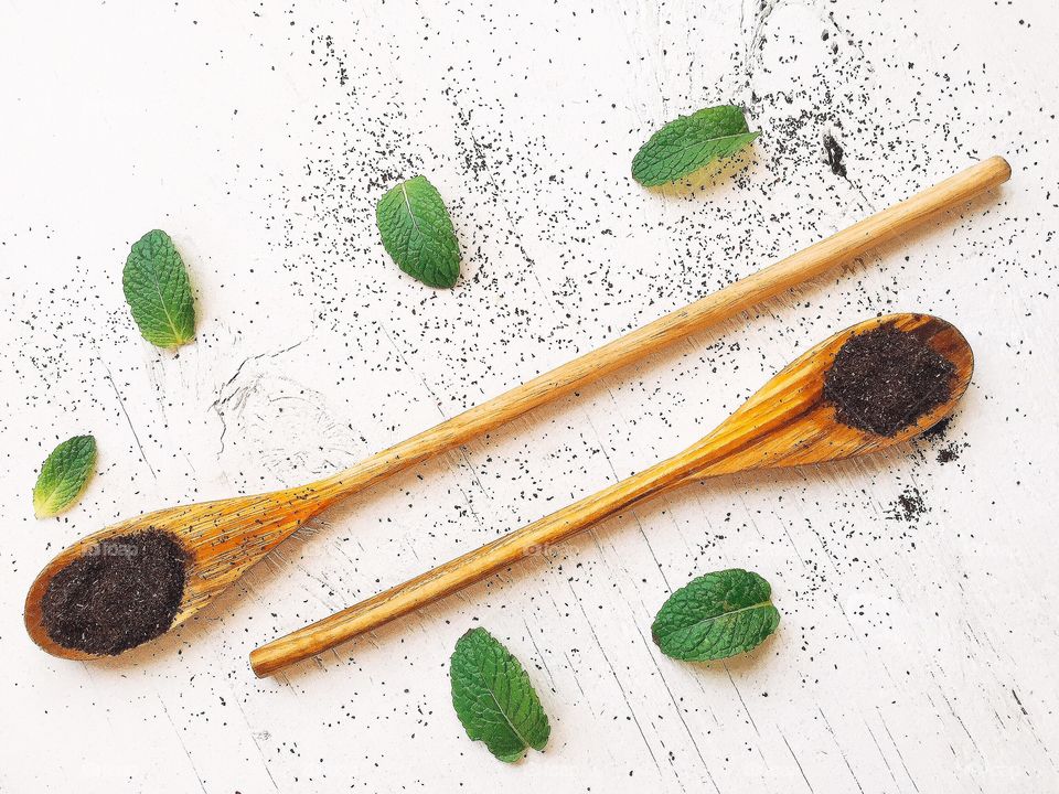 Tea leaves and mint in wooden spoon